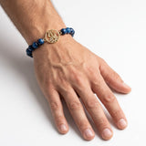 Designer Gold-Plated Trishul Rakhi with Dark Blue Stone Beads